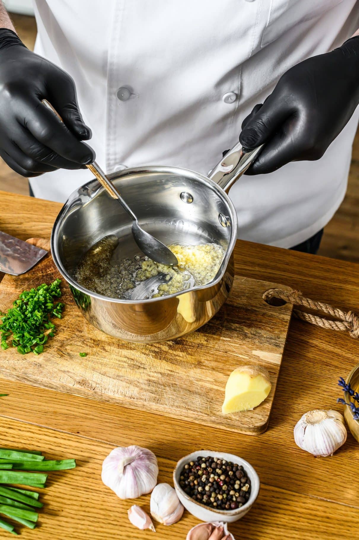 Chef stirring garlic in a pan.