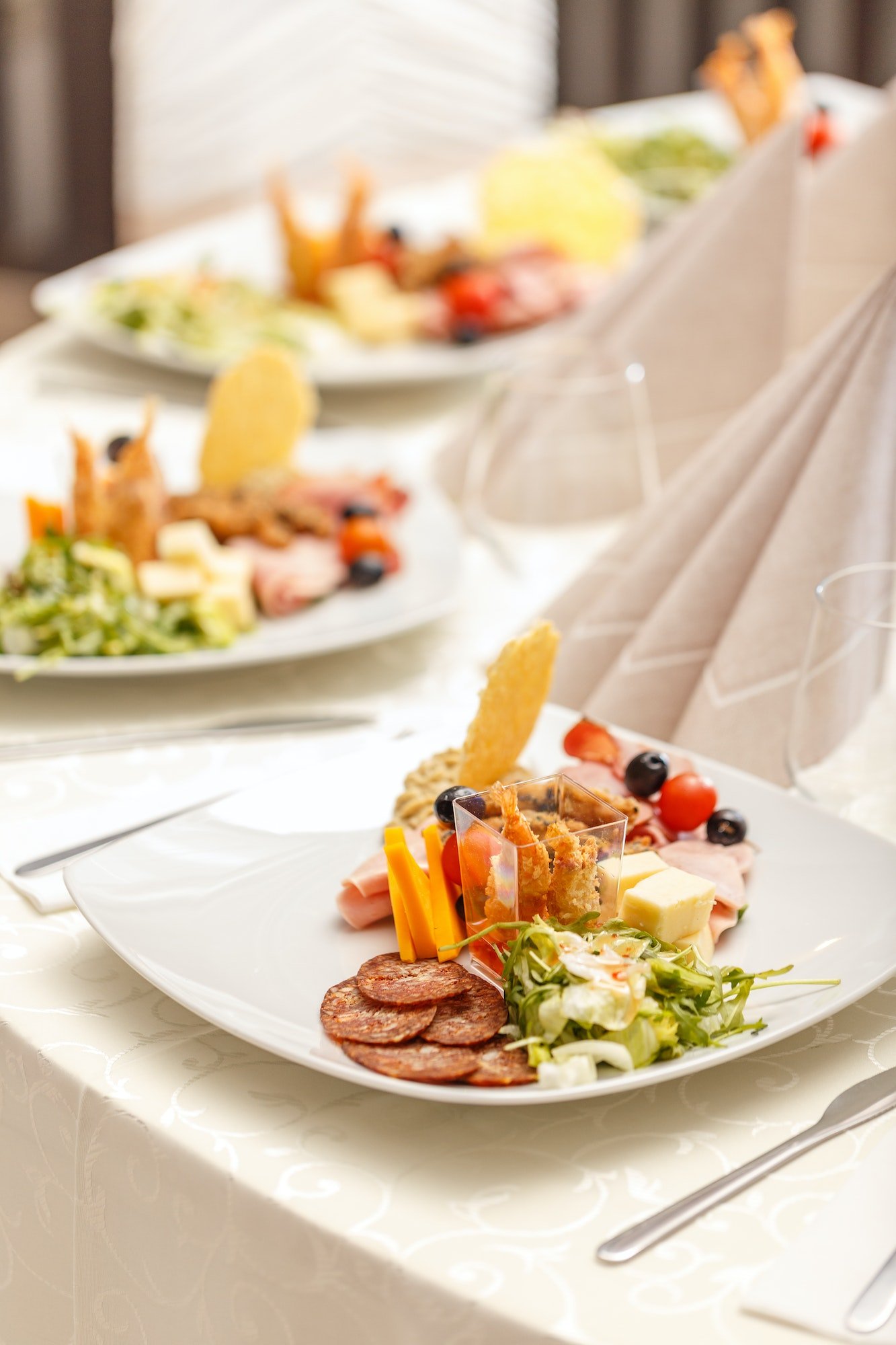 Appetizer plate with salami, cheese, and shrimp.