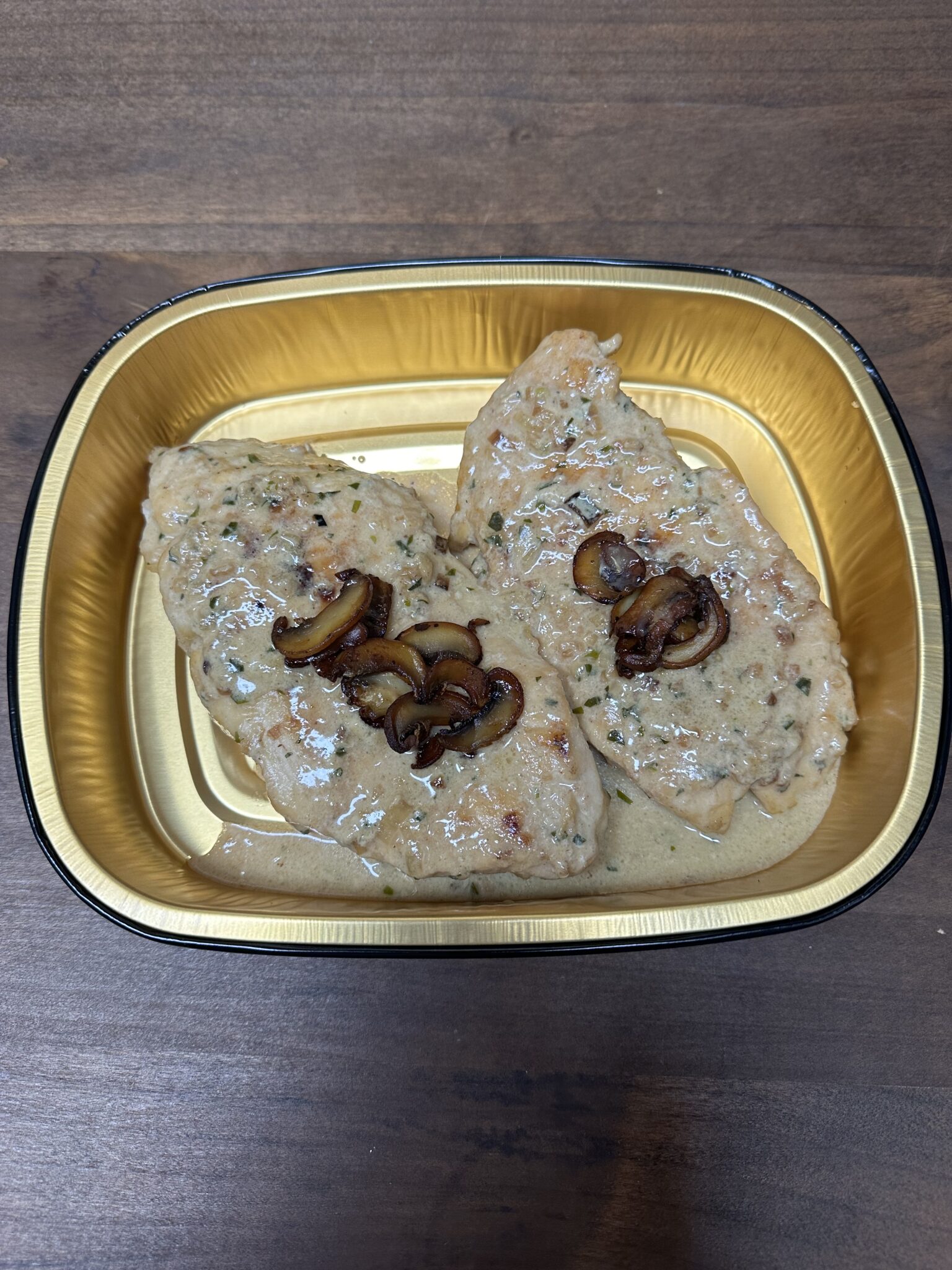 Chicken breast with mushroom sauce in a dish.