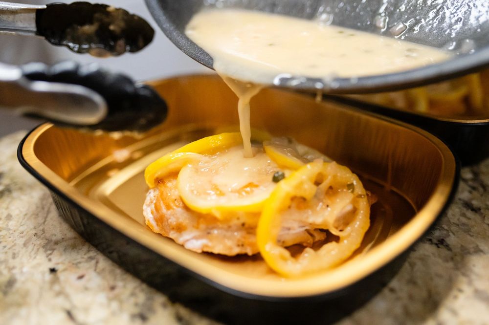 Lemon chicken with sauce in a dish.