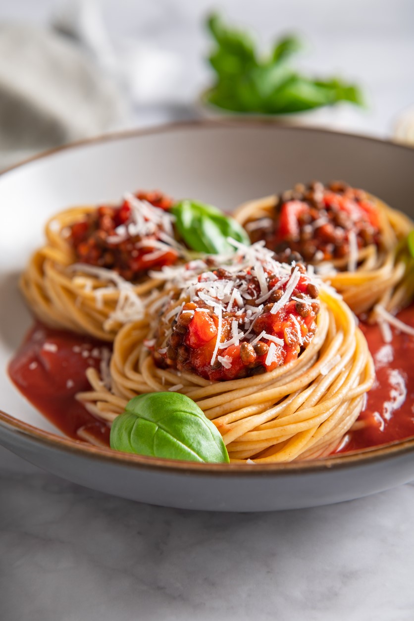 Spaghetti nests with meat sauce and basil.